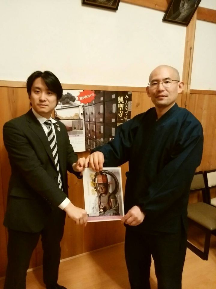寺社の方と行事の案内を手にする種田成昭
