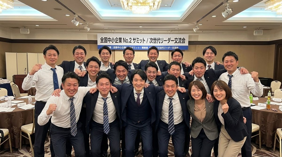 全国中小企業NO.2サミットの会場で、参加者と拳を上げて記念撮影