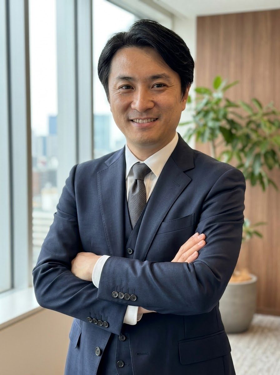 スーツ姿で腕を組む種田成昭