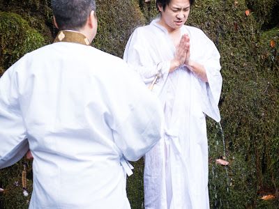 白衣で滝行をする種田成昭
