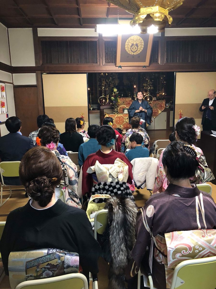 寺の本堂で、着物姿の参加者を前に話す種田成昭