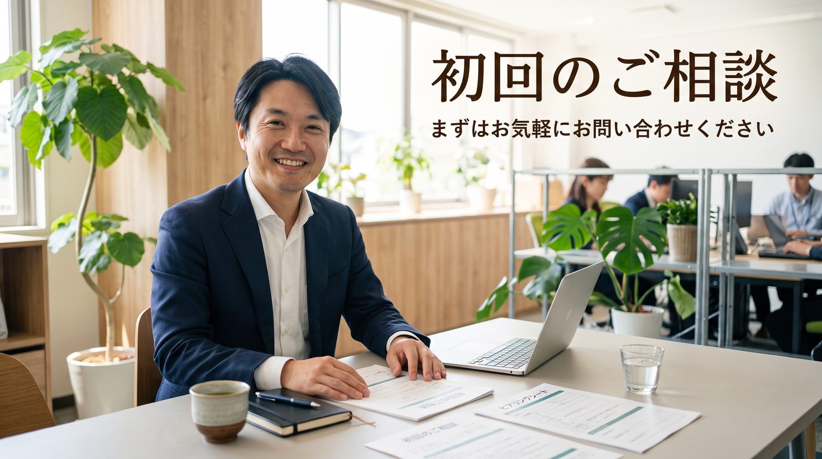 「初回のご相談」の文字と、机に向かってほほえむ男性(イメージ)